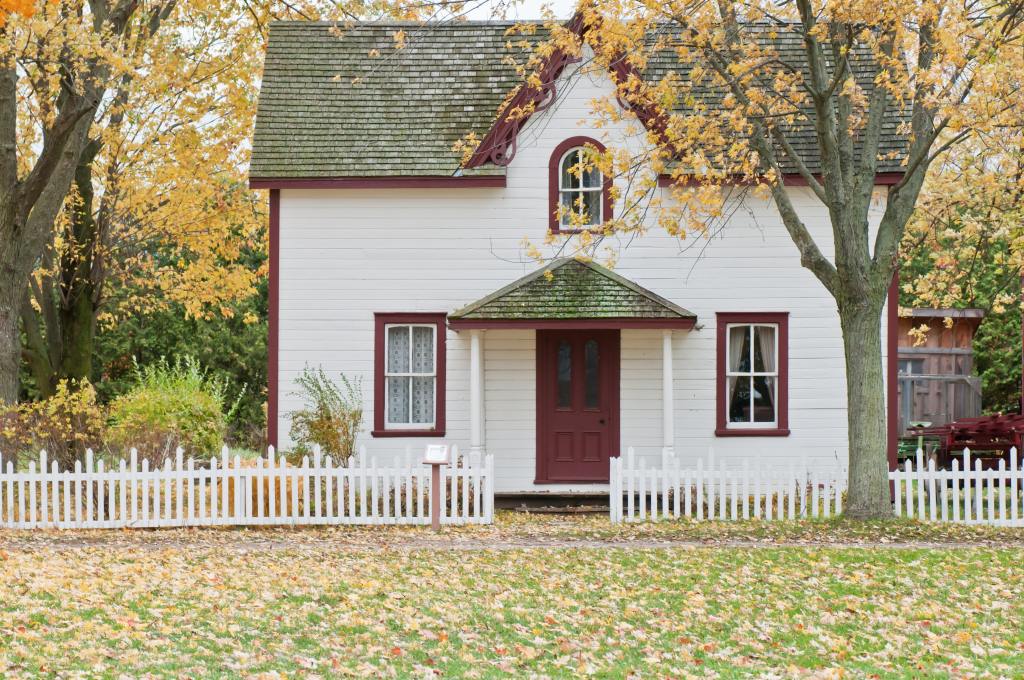 A small home with a white exterior and red assets.