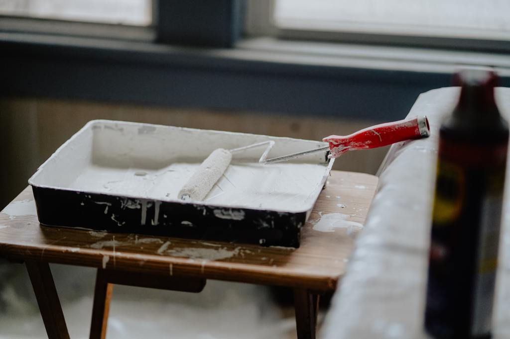 A photo of a roller covered in white paint.