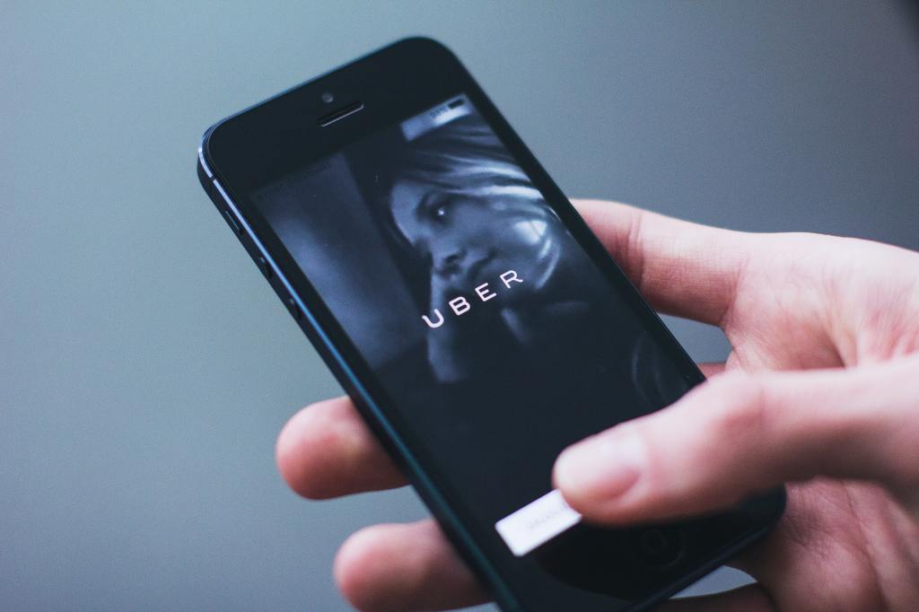 A person holding a phone with the uber app open.